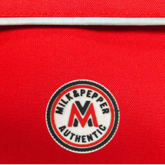 Détail écusson et matière sac backpacker rouge