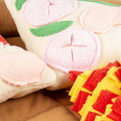 Zoom sur une zone du tapis pizza Duvo+ montrant les textures en polaire et les cachettes à friandises